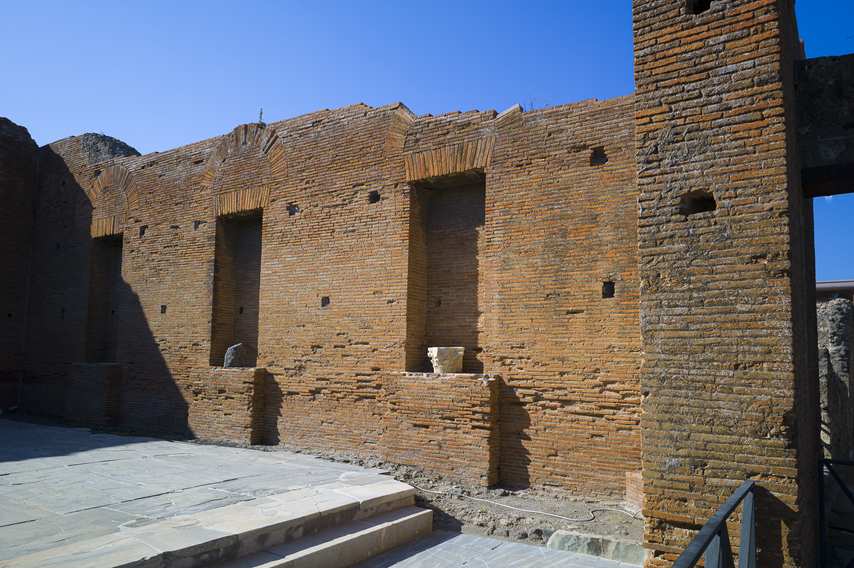 Dettaglio della parete in mattoni degli edifici municipali di Pompei, con nicchie e frammenti archeologici