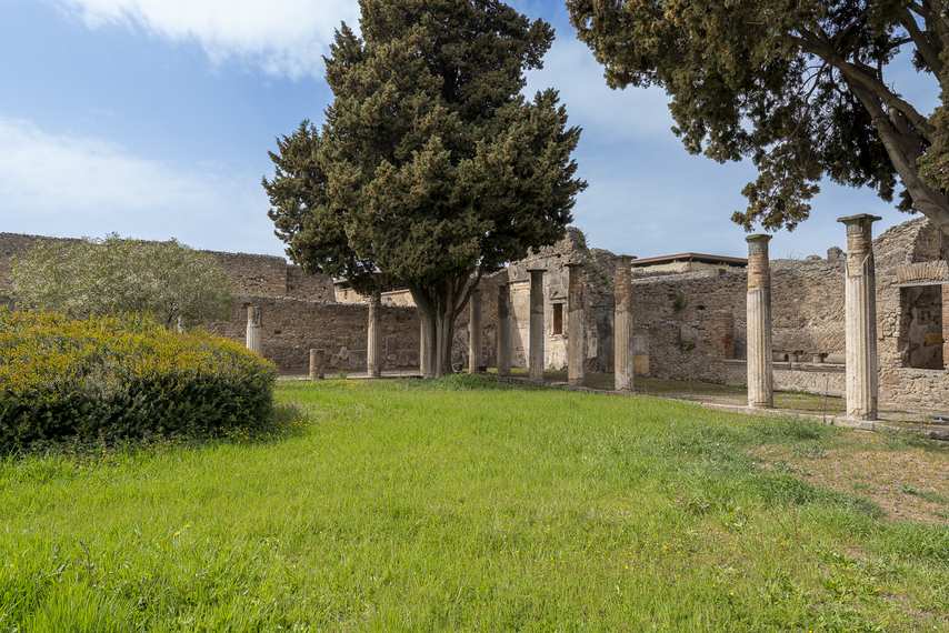 Colonnato della Casa del Fauno a Pompei con prato e cipressi