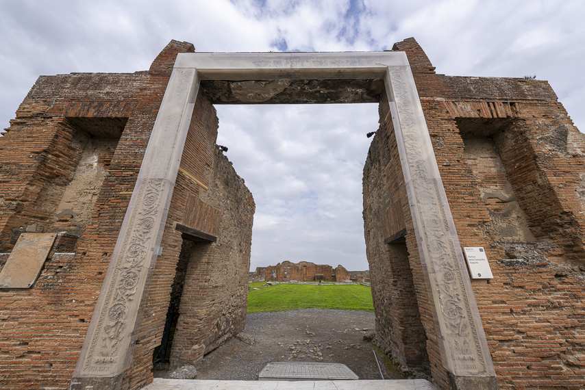 Ingresso del Portico della Concordia Augusta a Pompei con arco moderno e rovine antiche