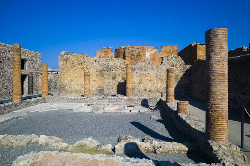 Rovine con colonne in mattoni nella Casa di Championnet a Pompei sotto un cielo sereno