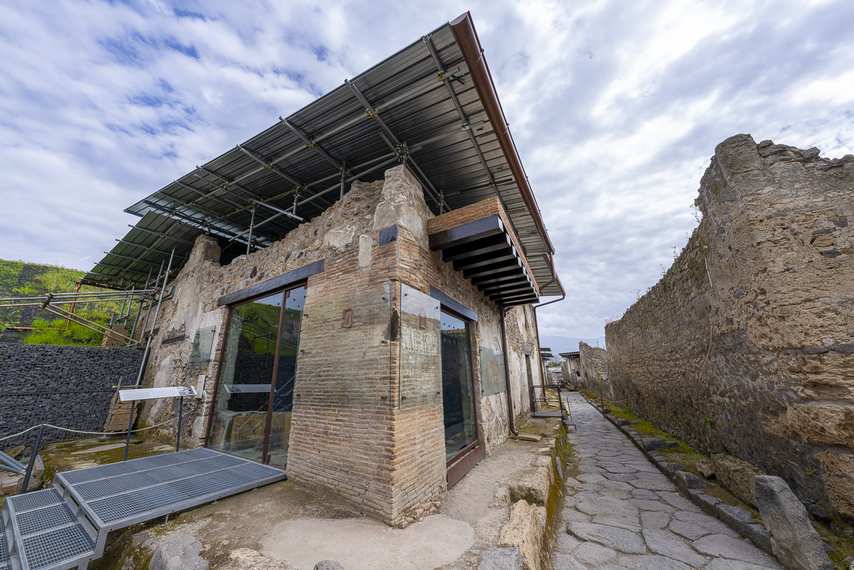 Esterno di un antico thermopolium di Pompei con tetto protettivo e vetrate moderne